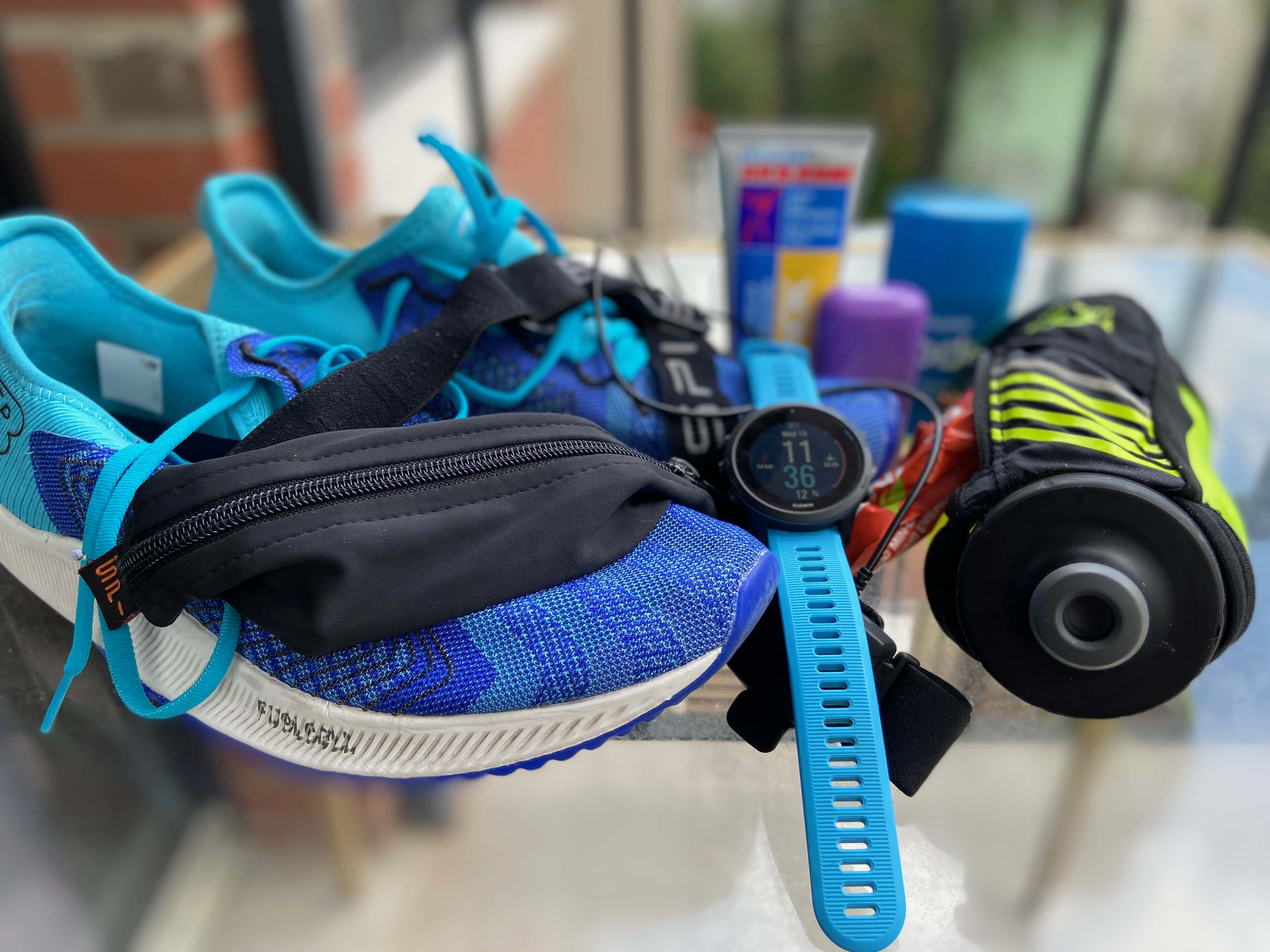 Picture of my gear, running shoes, watch, cream, balm, flask, HR monitor, gels & SPIbelt